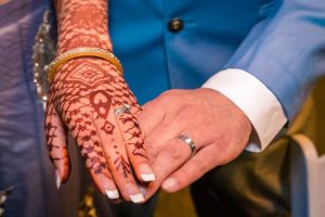 Melbourne wedding photographers captured the moment of henna tattooed brides hand holding to grooms hand, showing their wedding rings
