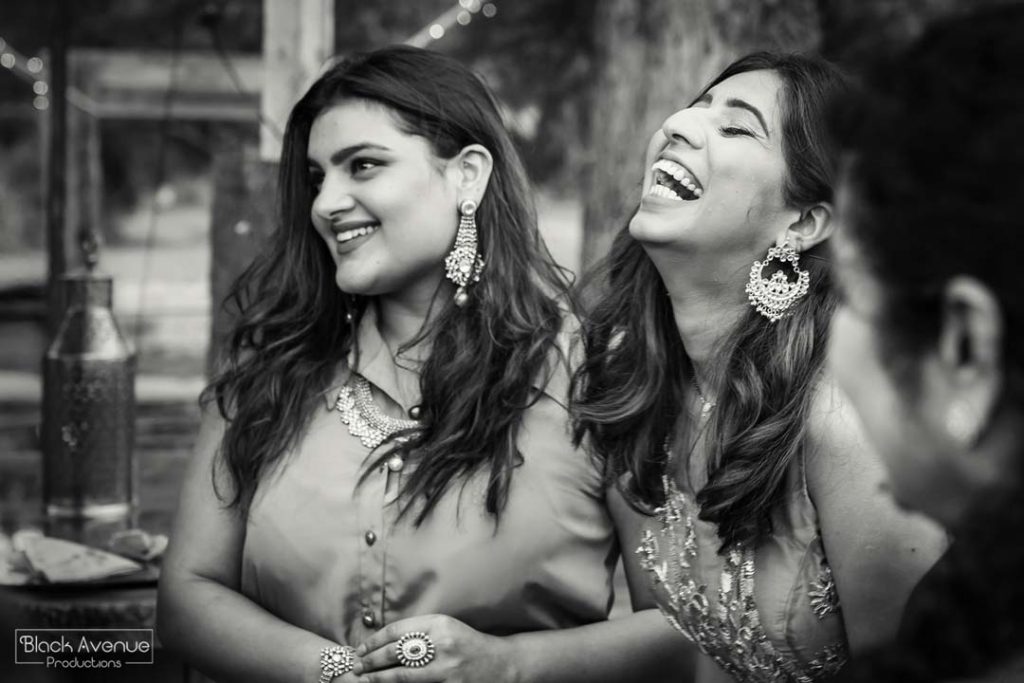 real candid moment of two girls laughing happily at their Baxter Barn melbourne wedding reception in black and white image