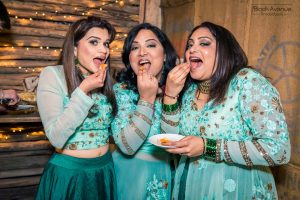 three cute bridesmaids cheekily eat wedding cakes in Baxter Barn in Melbourne