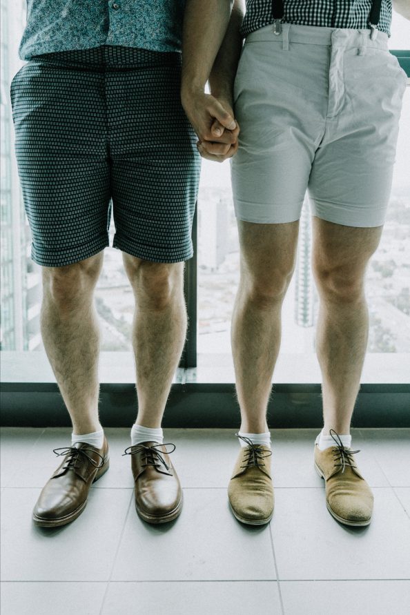 gay couple wedding party photo of their brown leather shoes and holding hands