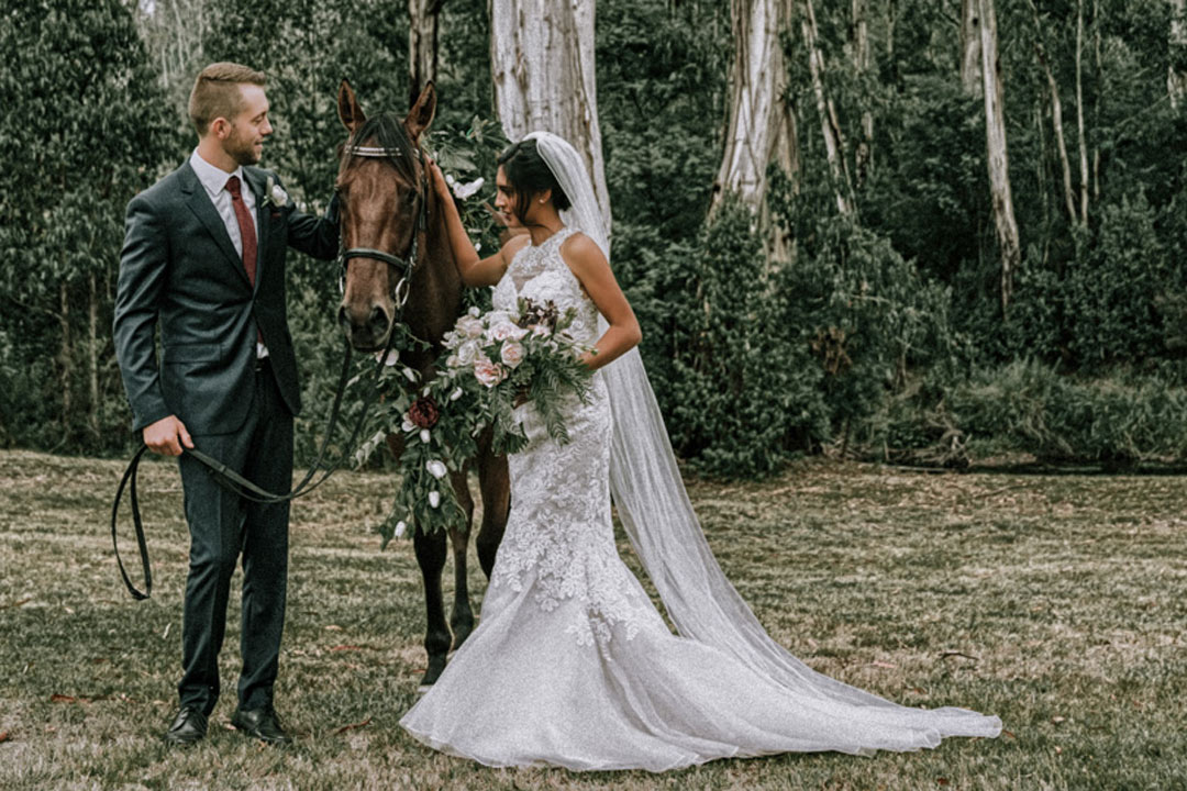 husband and wife newly wedded couple walking with pet horse at rustic farm wedding Melbourne