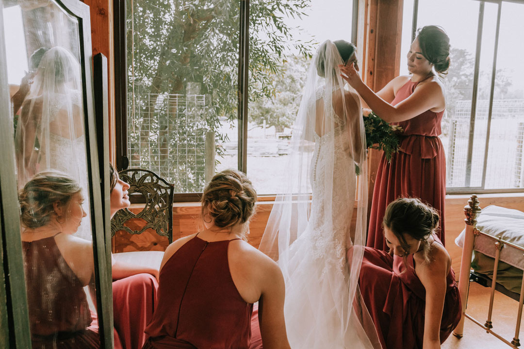 bride getting ready with bridesmaids help