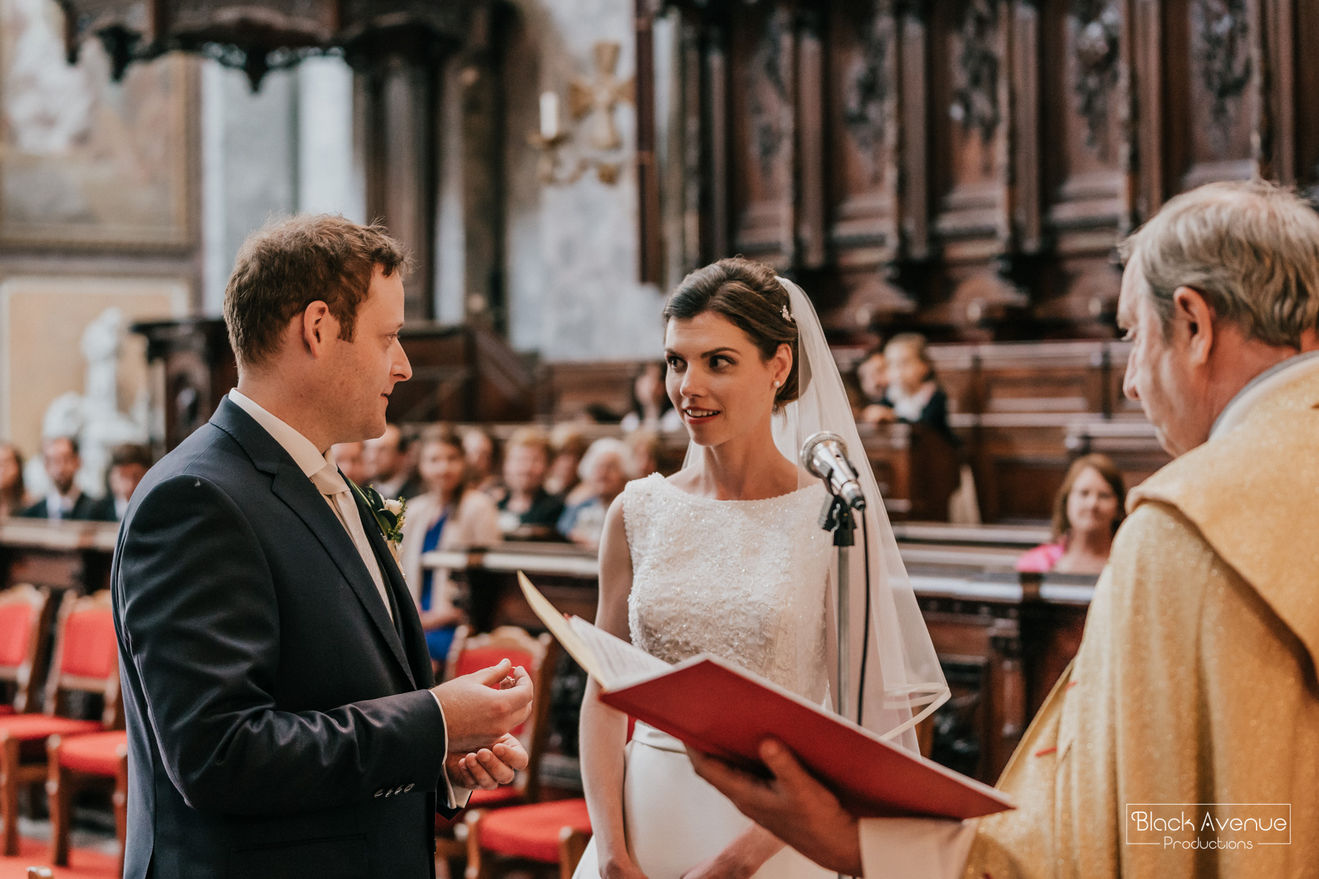 Candid moment of chapel wedding ceremony in the biggest church in Hungary by destination wedding photographers Black Avenue Productions