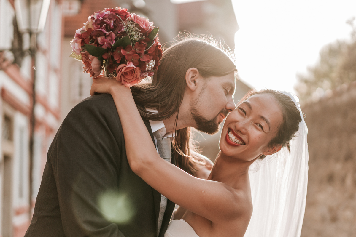 Husband kiss wife on cheek for their Prague destination wedding photography capture by Lowina Blackman from Black Avenue Productions