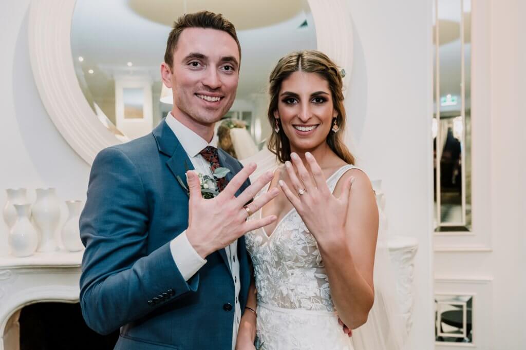 Melbourne couple showing off their wedding rings at their Brighton beach wedding reception as newly wed