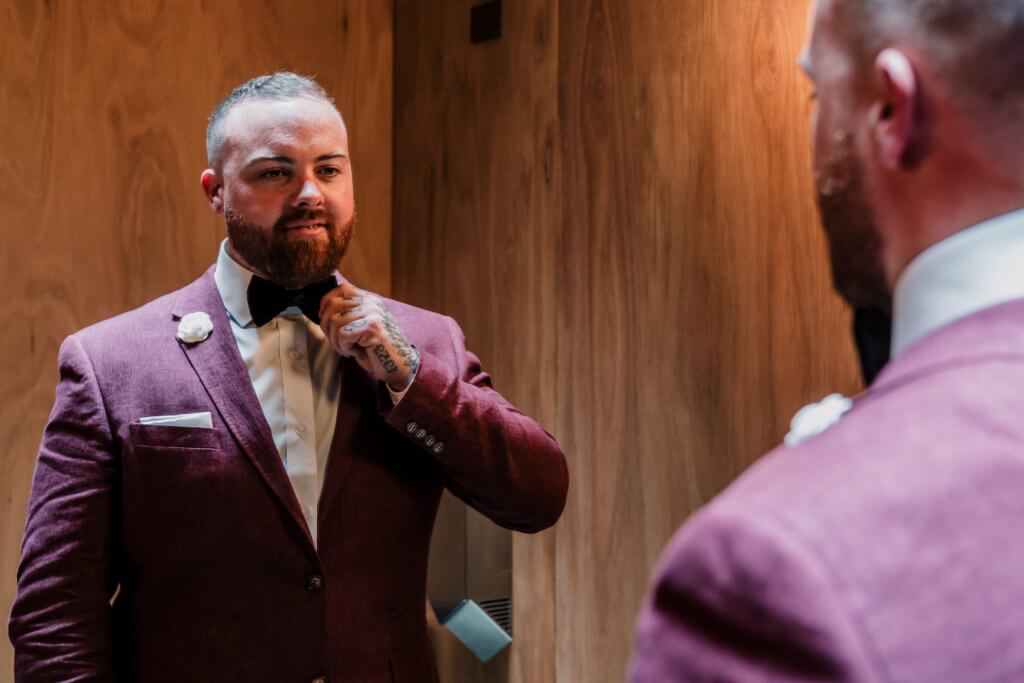 groom fixing his maroon suit or attire by menzclub