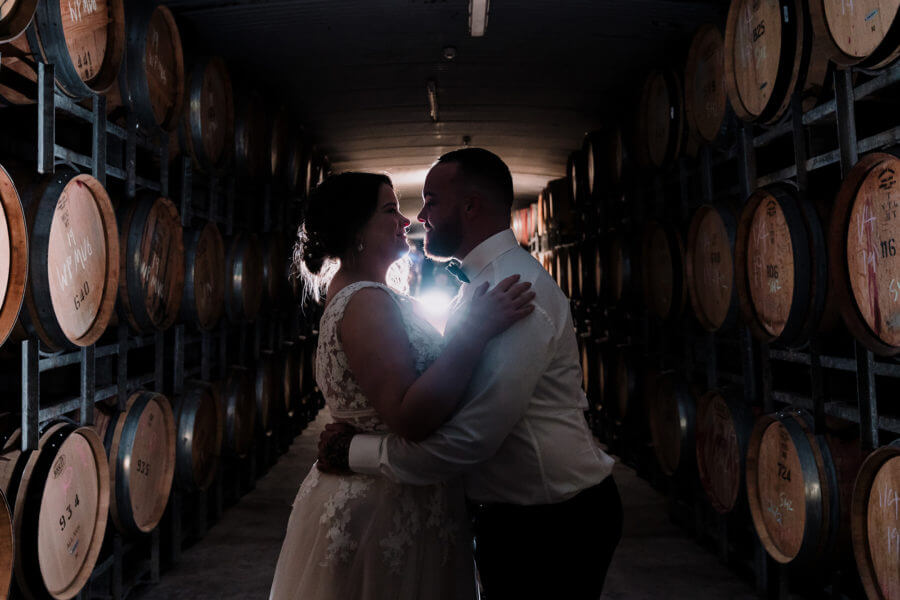 bride and groom kissing with a winery background for wedding portrait