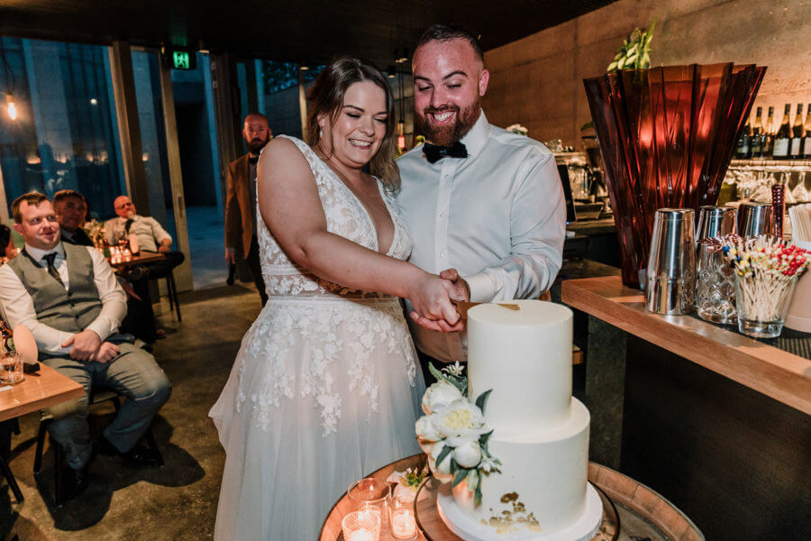 bride and groom slicing the cake happily shot by black avenue productions