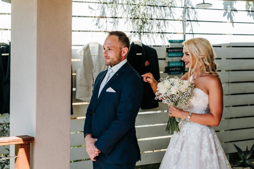 bride tapping the groom's shoulder in first look wedding tradition