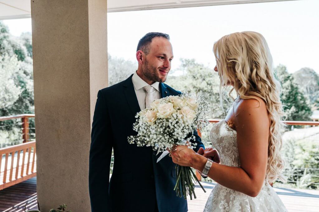 groom staring at his bride with teary eyes in first look wedding tradition