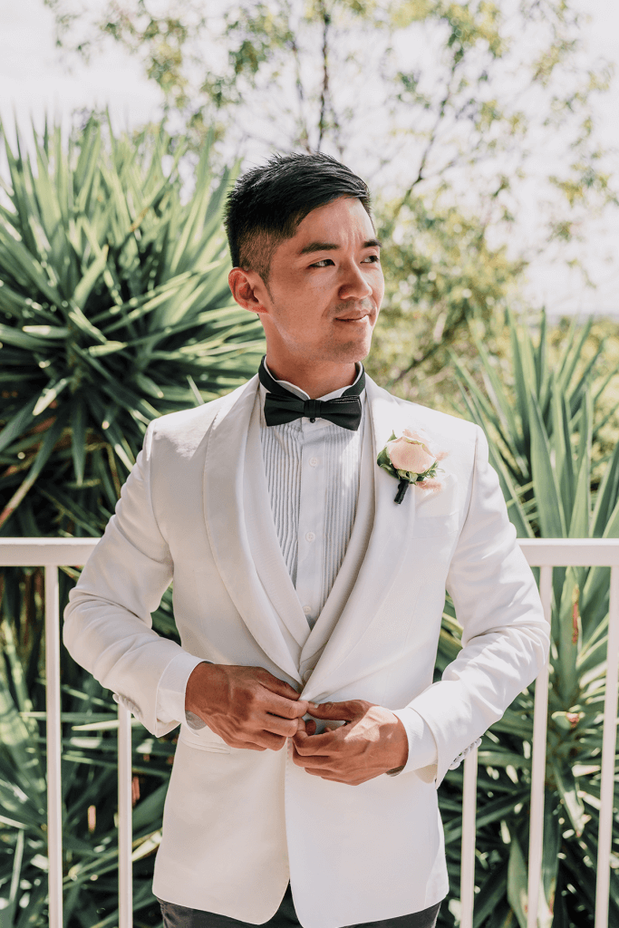 asian groom wearing white tuxedo in a magical melbourne city wedding photo by black avenue productions