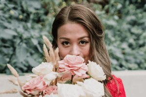 bride wearing red dress holding bouquet with pink and white roses