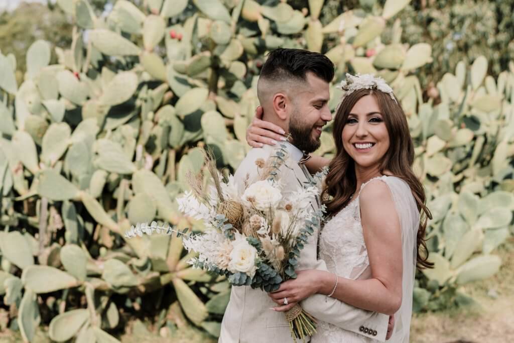 Destination Wedding - Couple smiling with flowers in the background