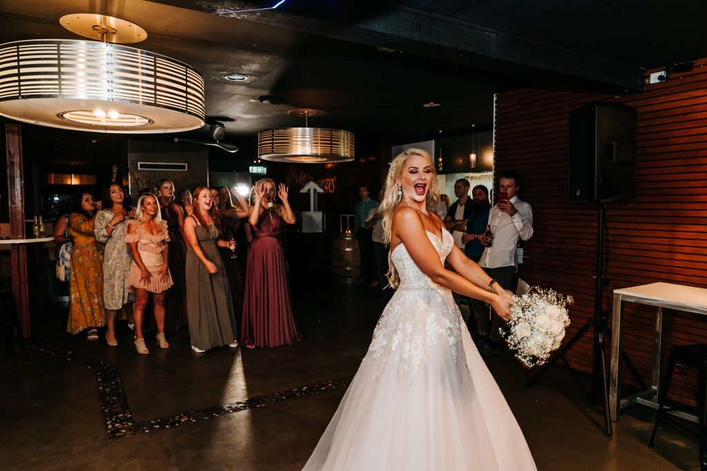 bride about to throw the bouquet to the excited ladies, captured by black avenue productions