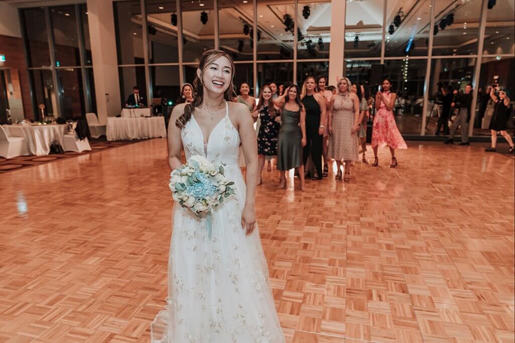 lovely bride smiling and ready to toss the bouquet. captured by black avenue productions