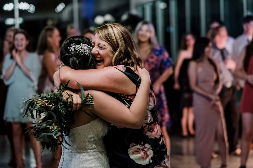 bride hugging her friend who caught the bouquet. captured by black avenue productions