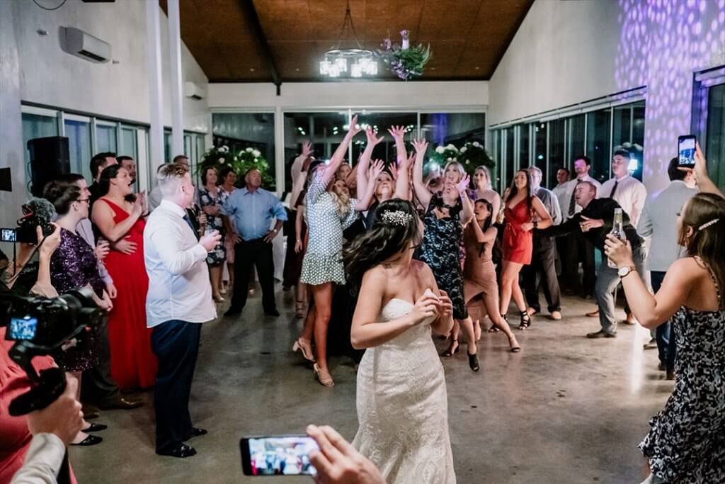 How to throw your bouquet in wedding, bride watches as her lady guests are catching the bouquet. captured by black avenue productions