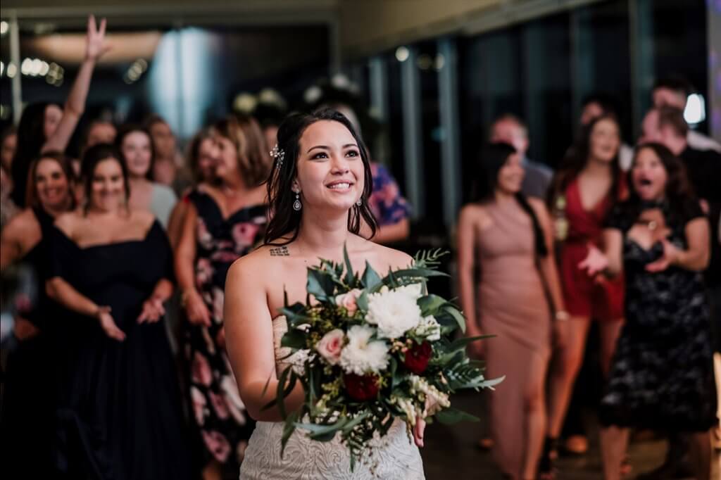 lovely bride smiling and getting ready to toss the flowers. captured by black avenue productions