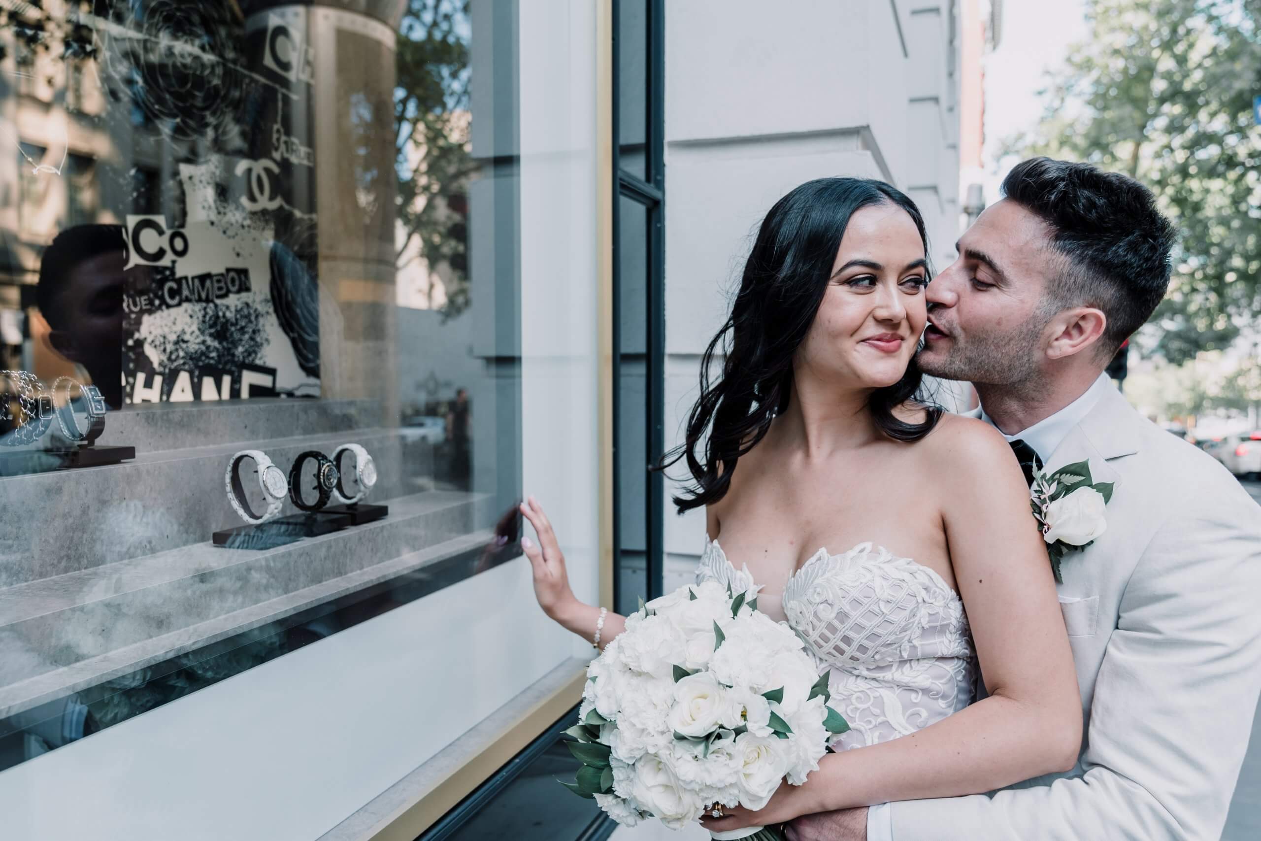 Lovely couple happily pose outside a store window in the city, captured by black avenue productions