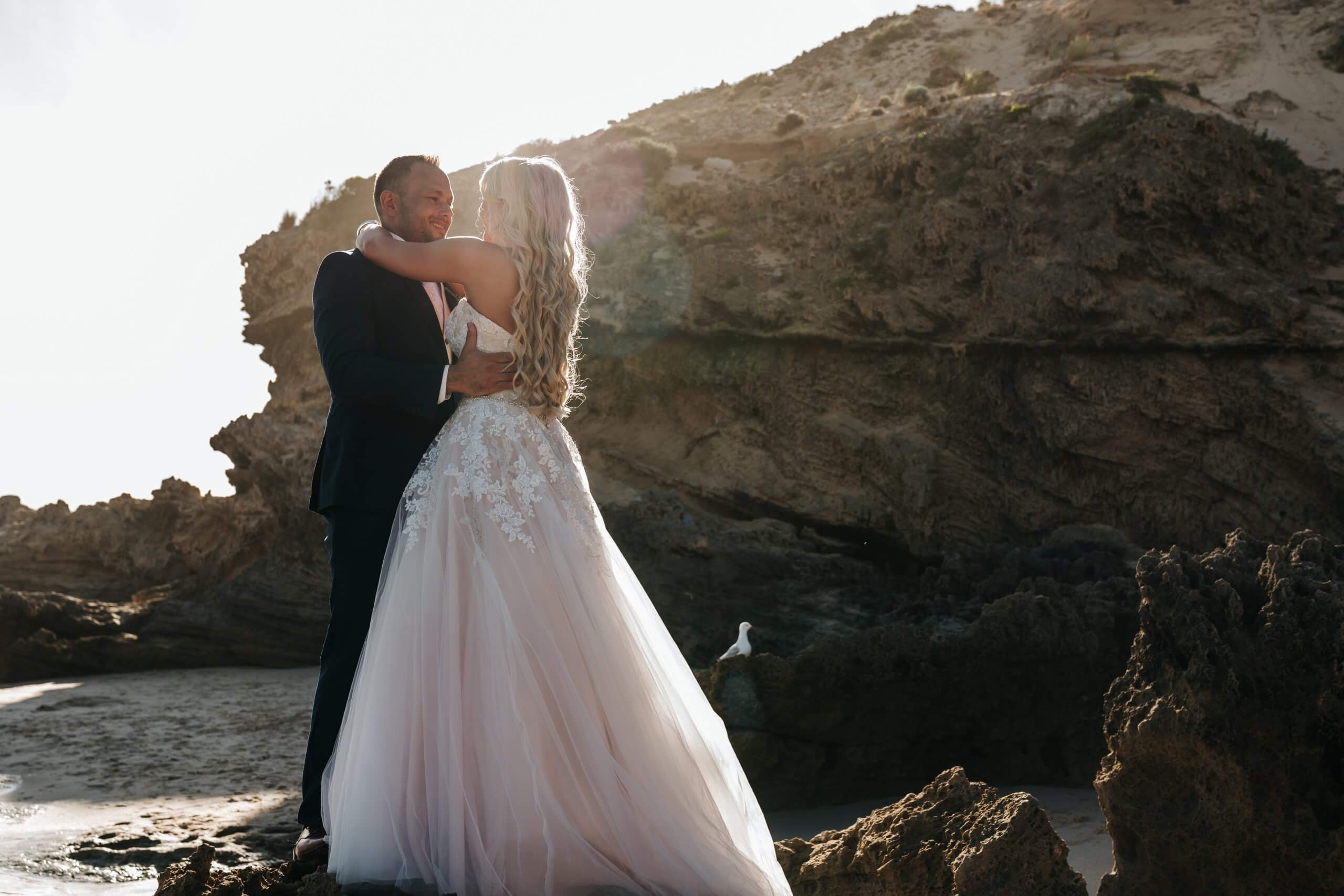 Bride and Groom lovingly holding each other by the beach. Captured by Black Avenue Productions