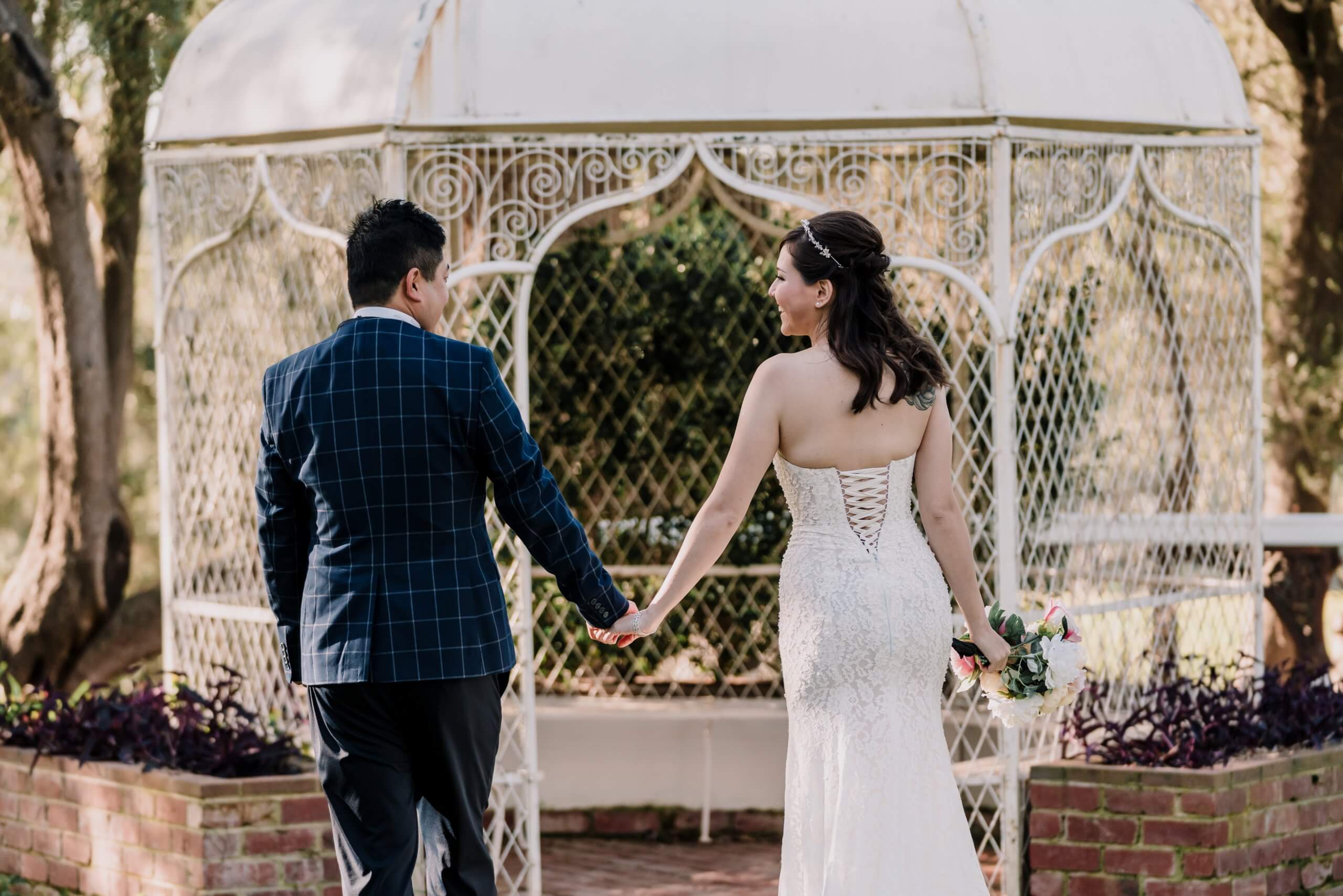 Newly Engaged Couple holding each others hand by a gazeebo at Overnewton Castle in Australia