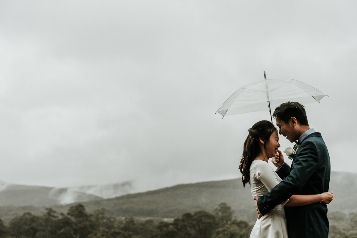 What if your wedding day is interrupted by rain? These lovely couple braved the rain, by holding a transparent umbrella and pose to show the wonderful view, captured by Black Avenue Productions