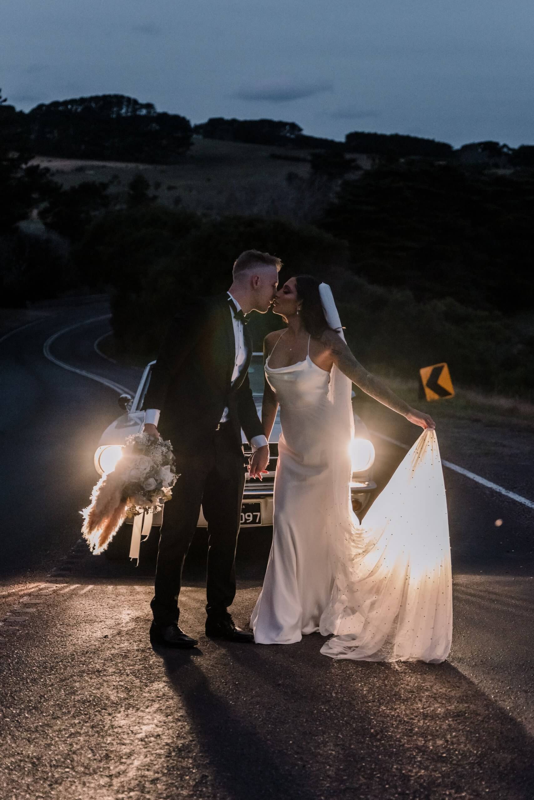 a lovely shot of the bride and groom kissing in the middle of the street, captured by black avenue productions