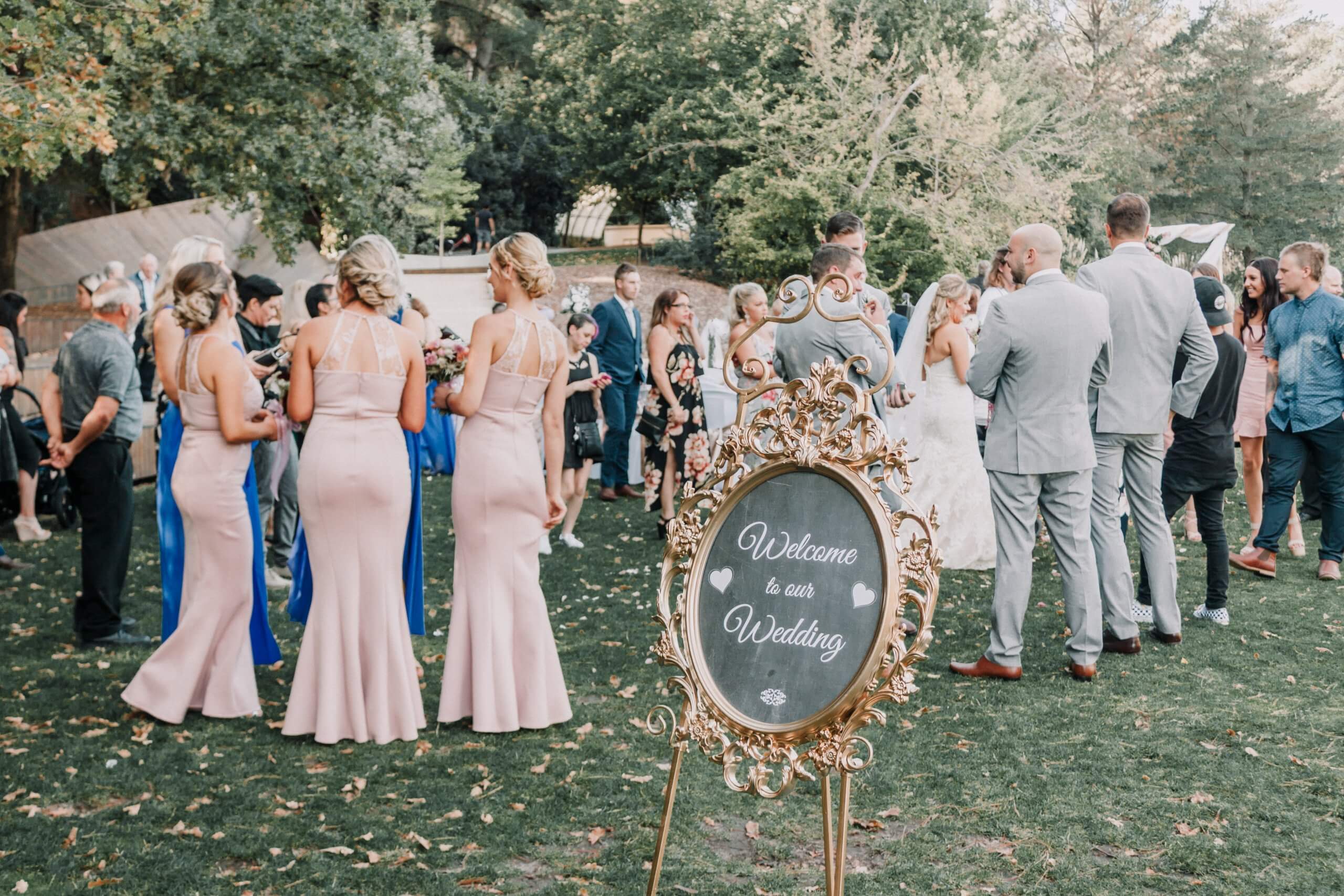 Guests are busy chatting and a board with the welcome sign. Captured by Black Avenue Productions