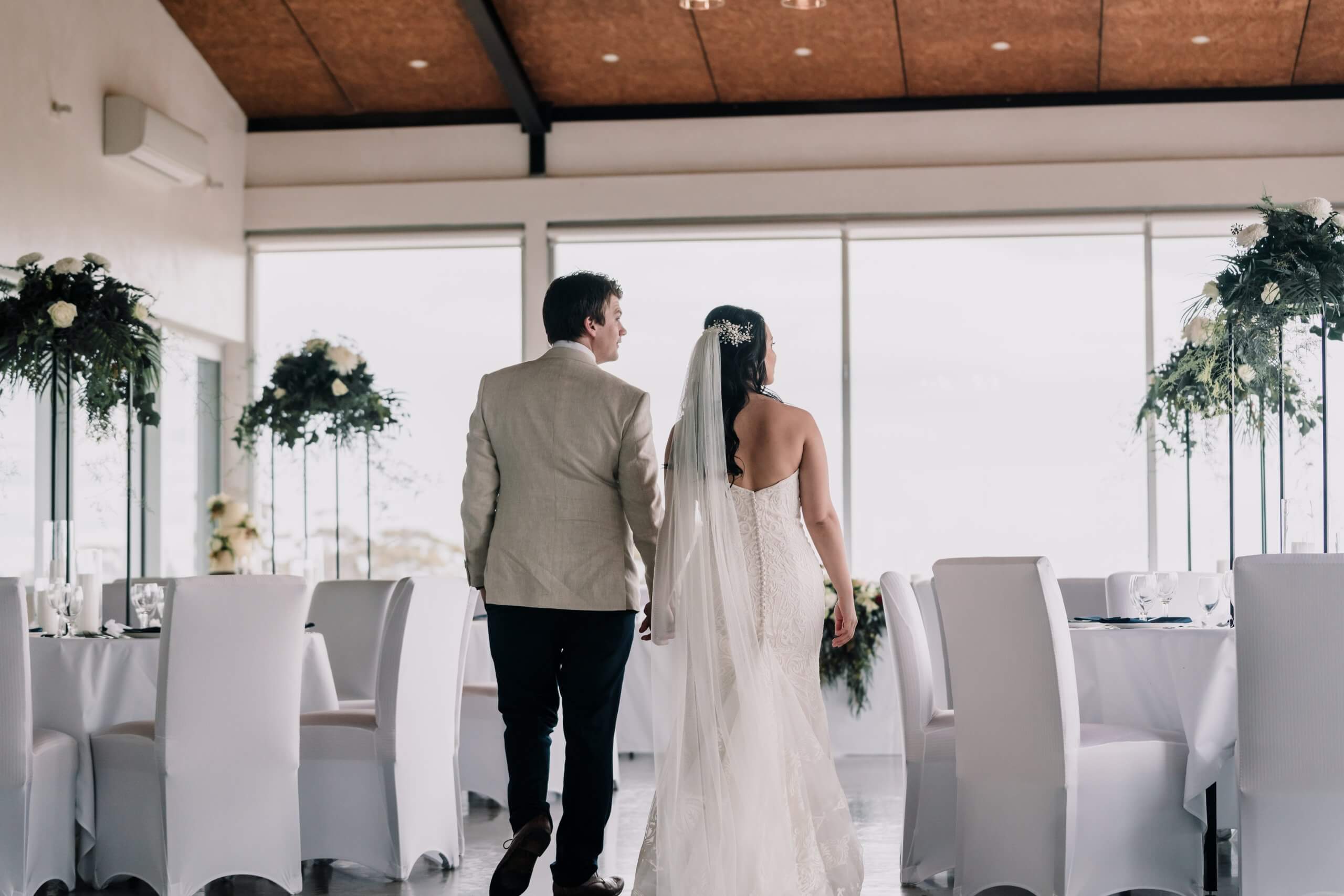 Planning An Intimate Wedding, newly wed couple walking in the reception of the wedding while guests are not yet around. Captured by Black Avenue Productions