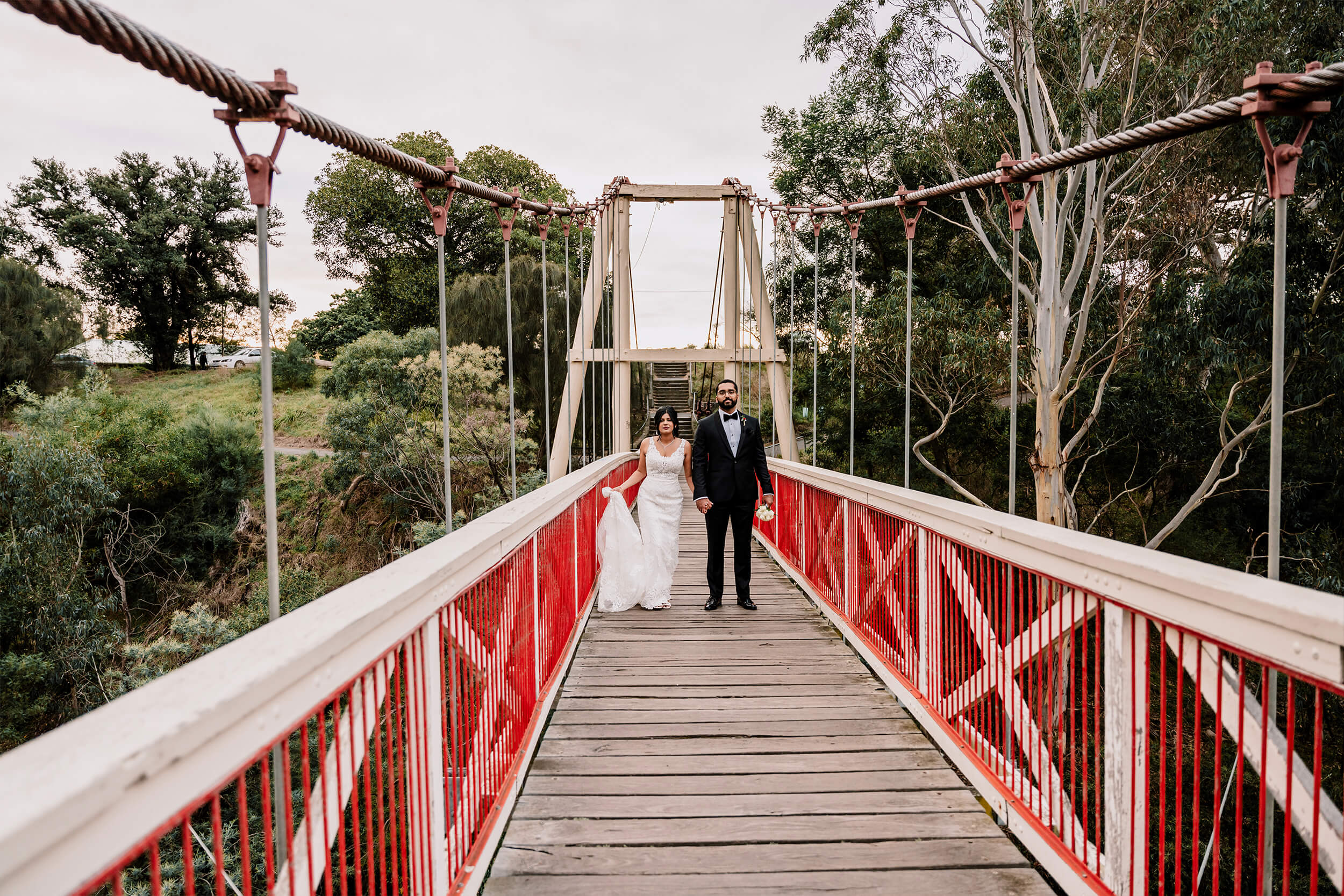 Engagement Shoot Preparations, a lovely shot of the couple as they walk through a hanging bridge , captured by Black Avenue Productions