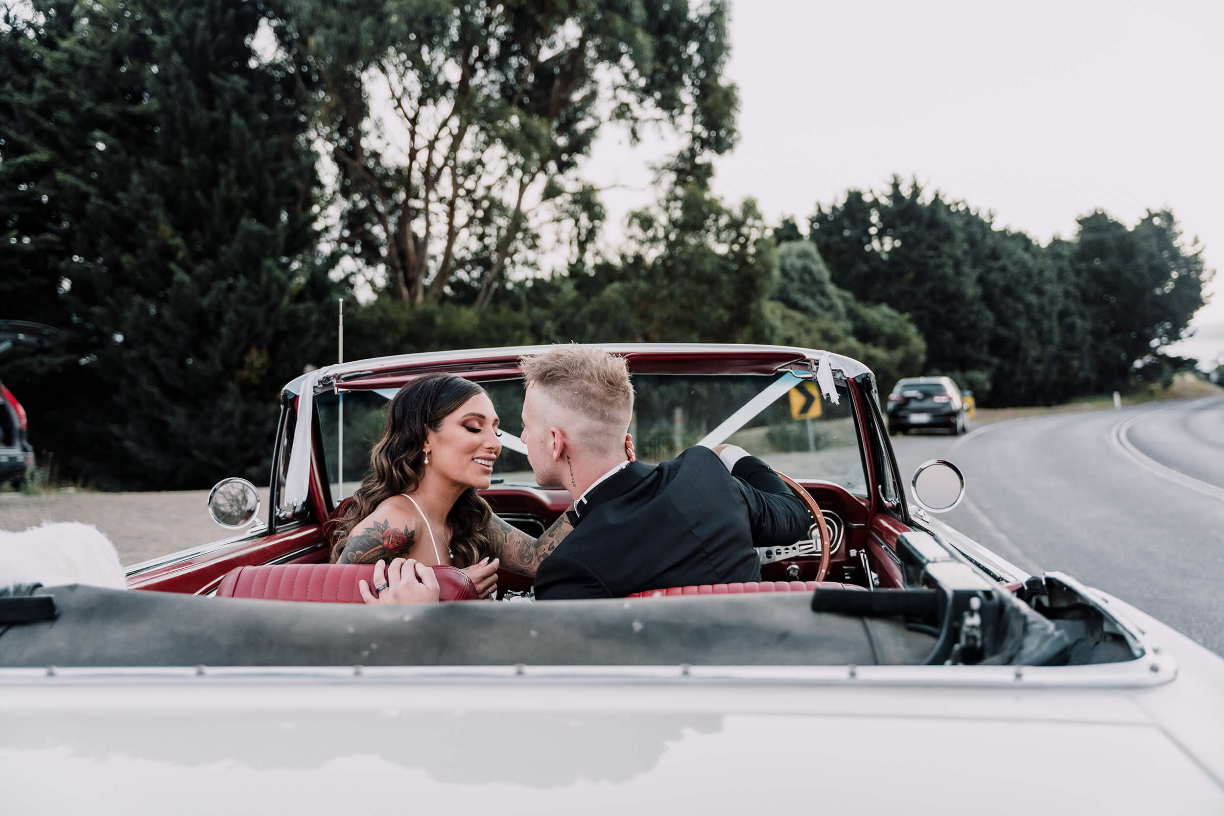 Wife and groom, staring at each other while smiling inside the car, captured by Black Avenue Productions