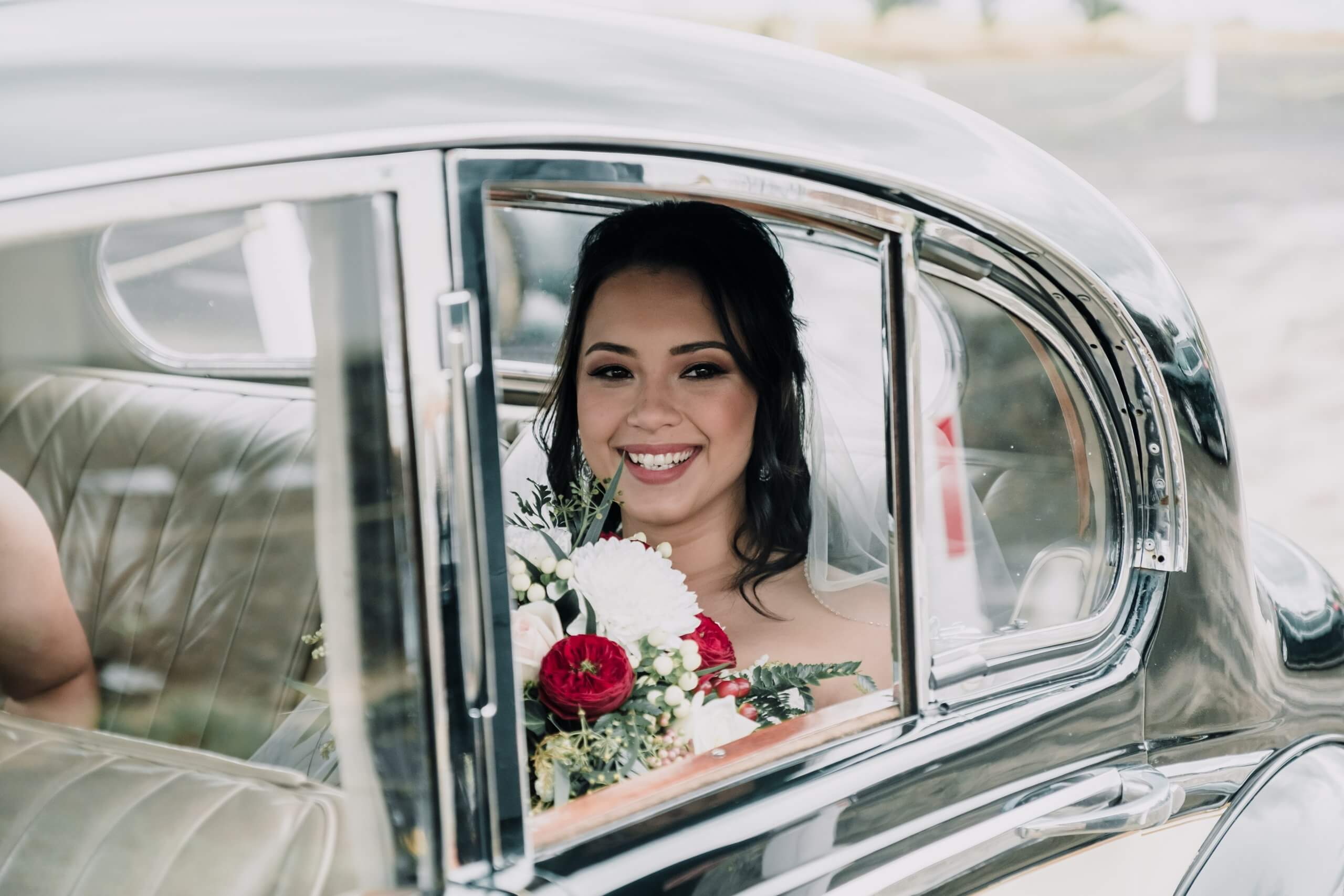 Get a wedding car, beautiful bride smiling inside the wedding car on the way to the venue, captured by Black Avenue Productions