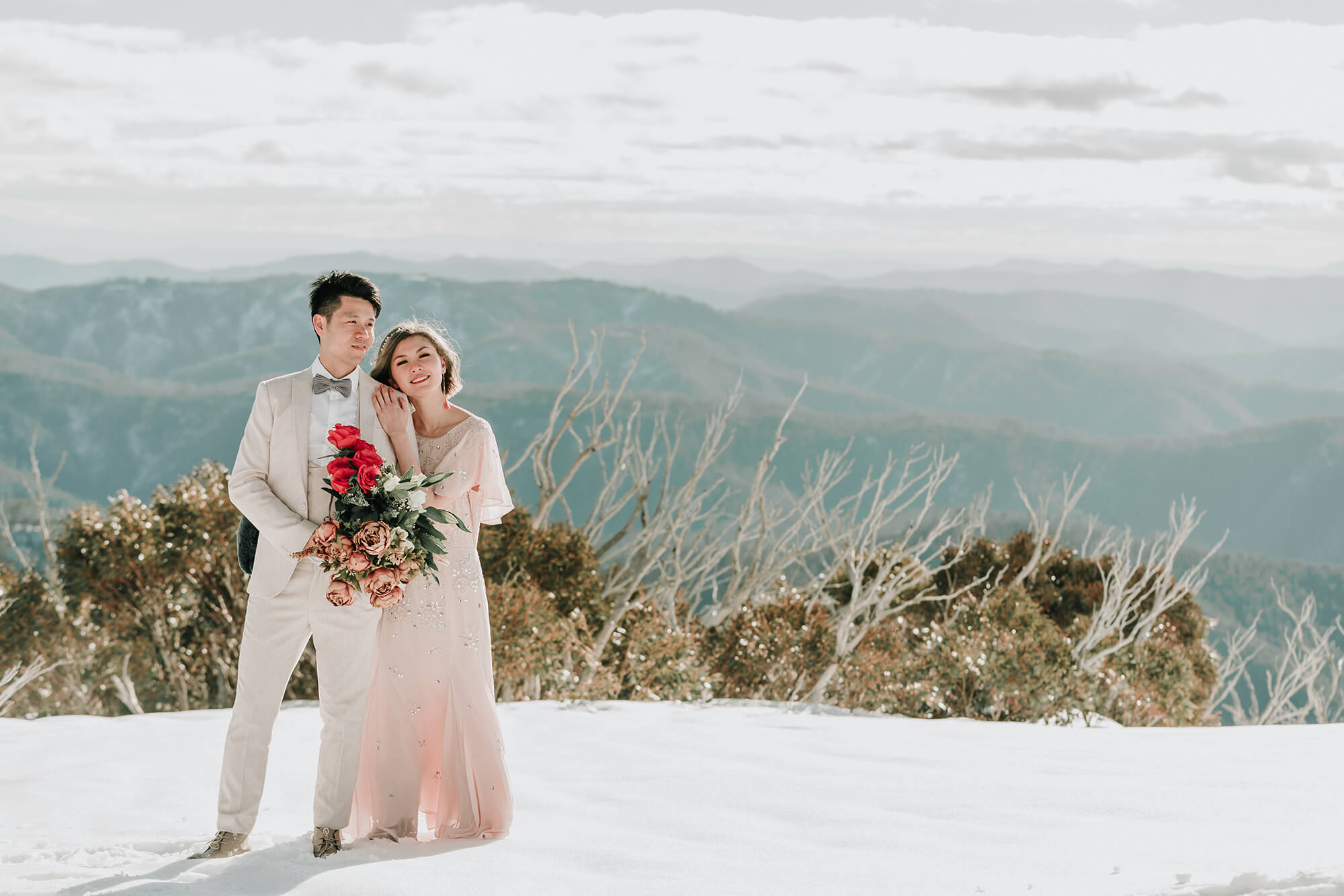 Engagement Photo Ideas, a lovely photo of the couple in a mountain covered in snow by Black Avenue Productions