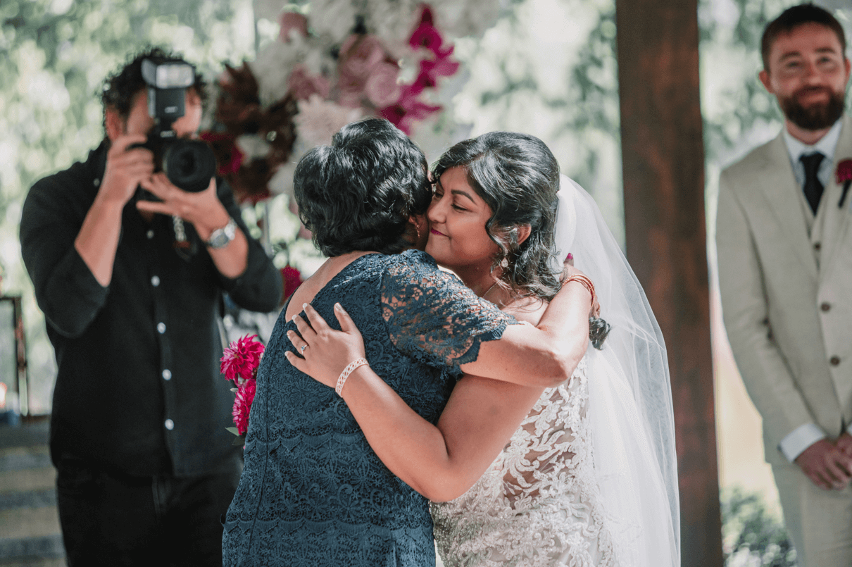 Mom and bride hugging in front of the altar before she leads her daughter towards the waiting groom.