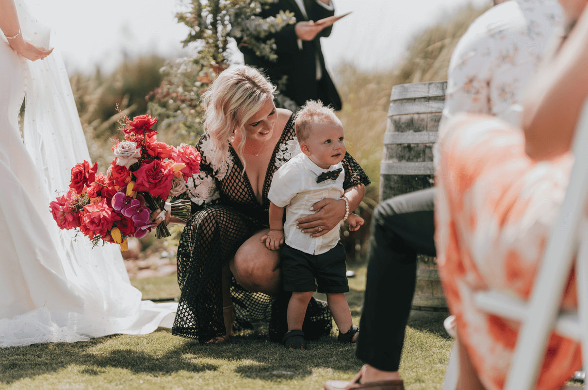 Bridesmaid stopping her son from running in front of the altar