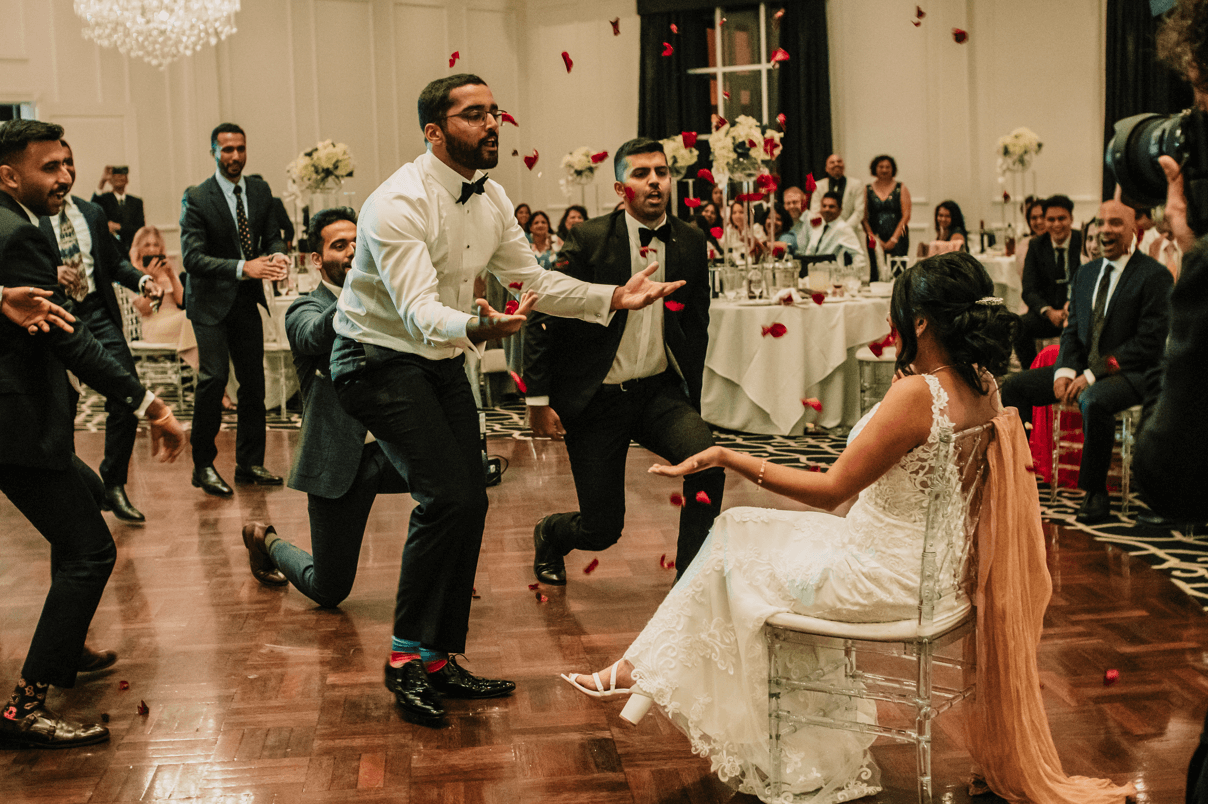 Groom and his groomsmen offers a goofy dance in front of the bride.