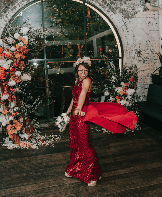 Bride twirling in her red reception dress.