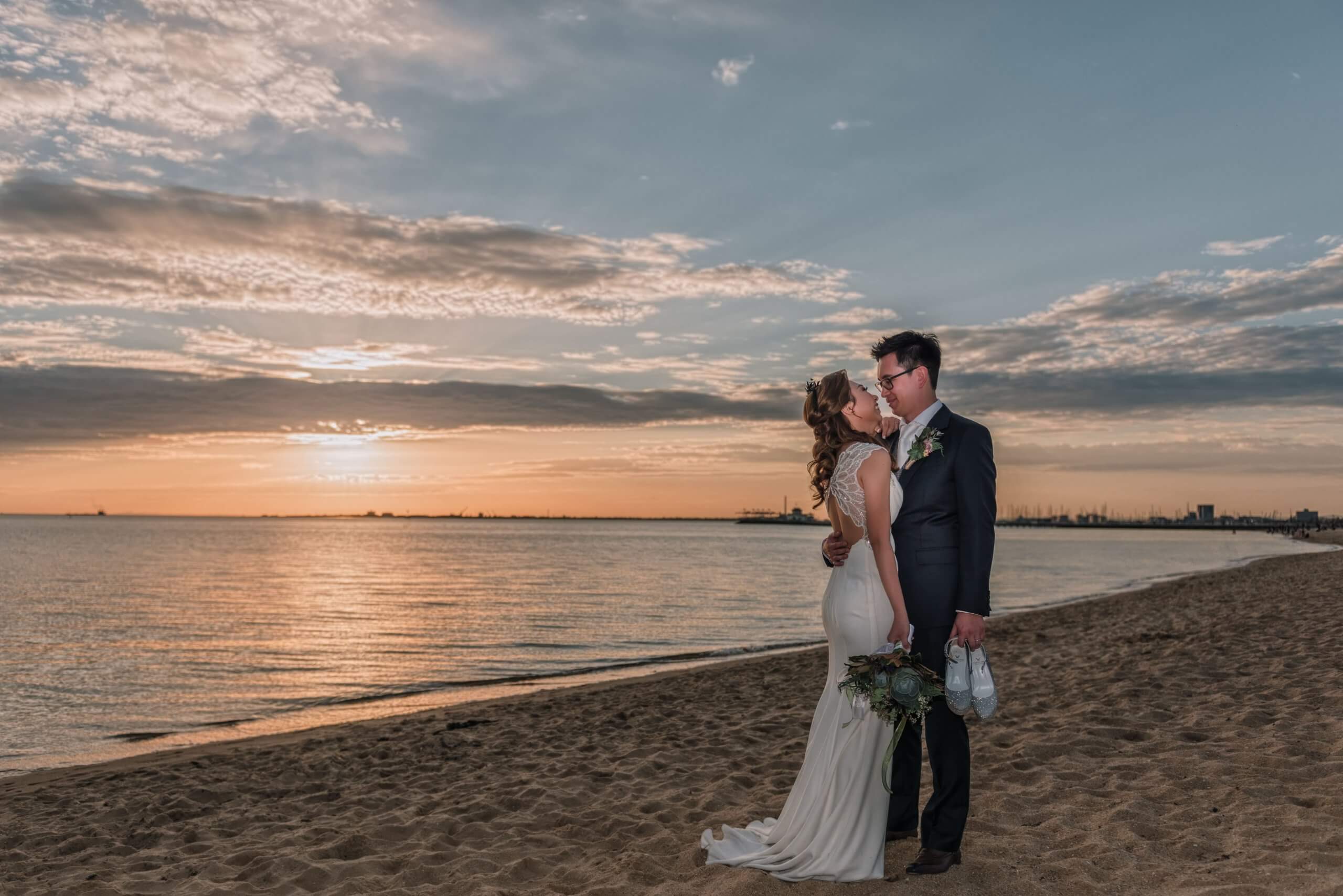 Cinematic photo of the bride and groom in the shoreline.