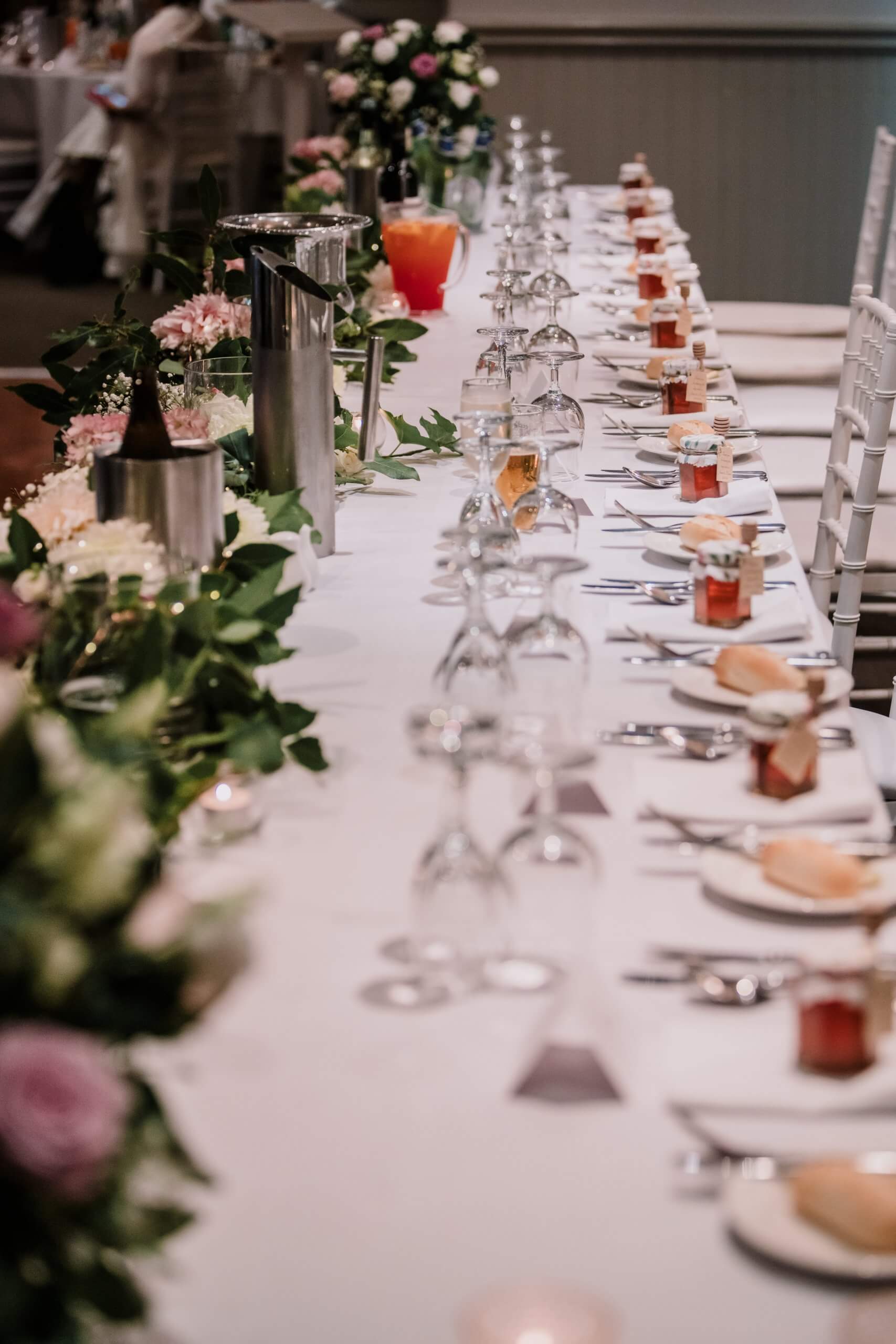 Long bridal table lined with flowers.