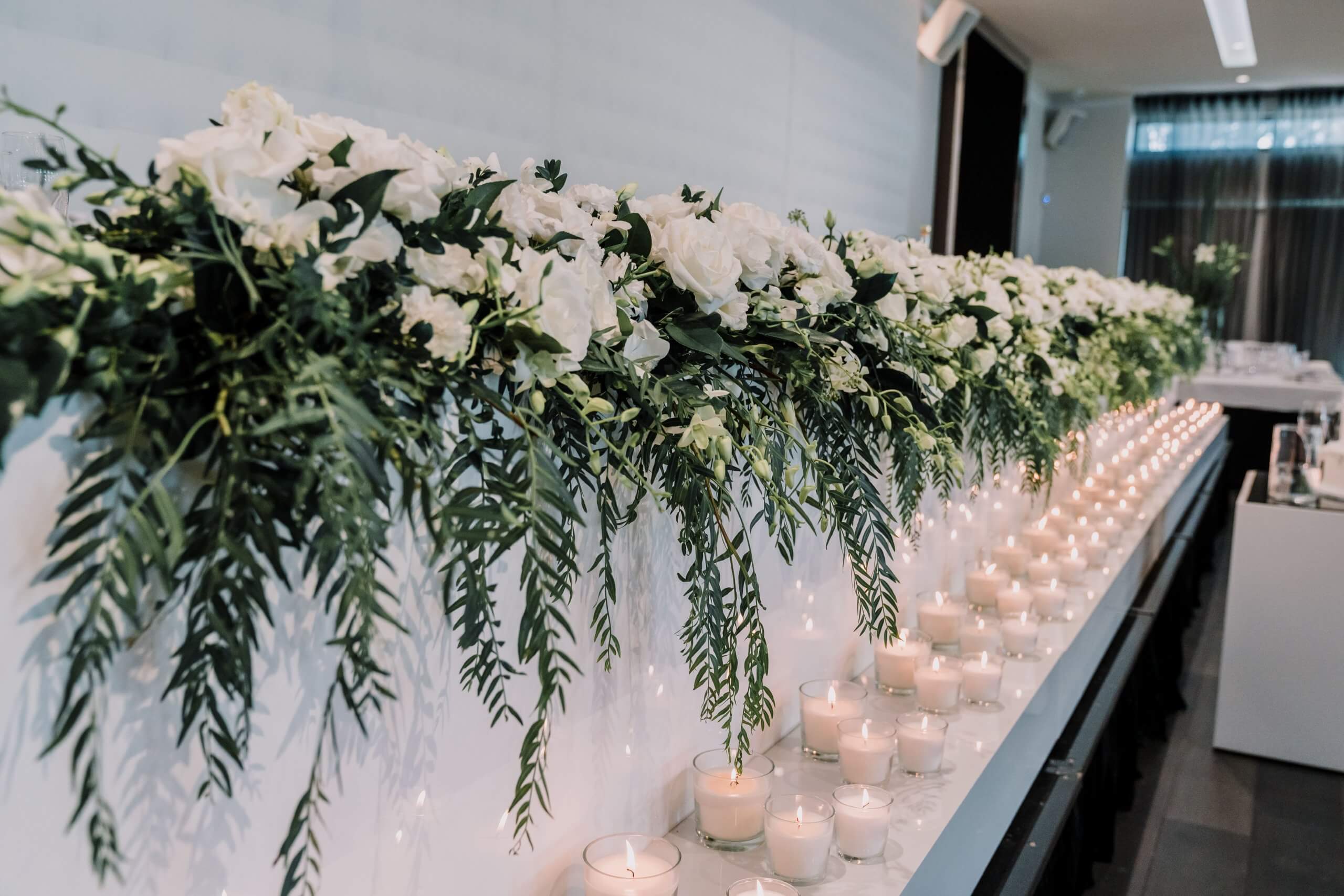 Beautiful floral arrangements and white candles lining the reception.