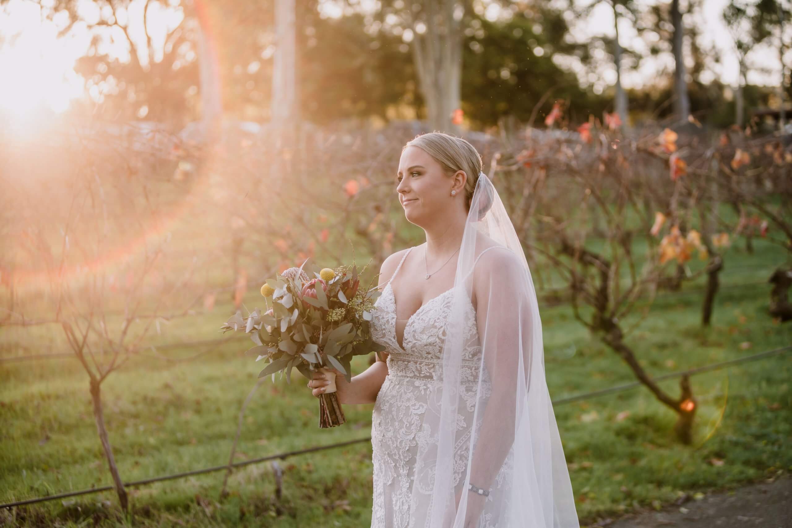 Bride looks beautiful while standing under the glow of the setting sun.