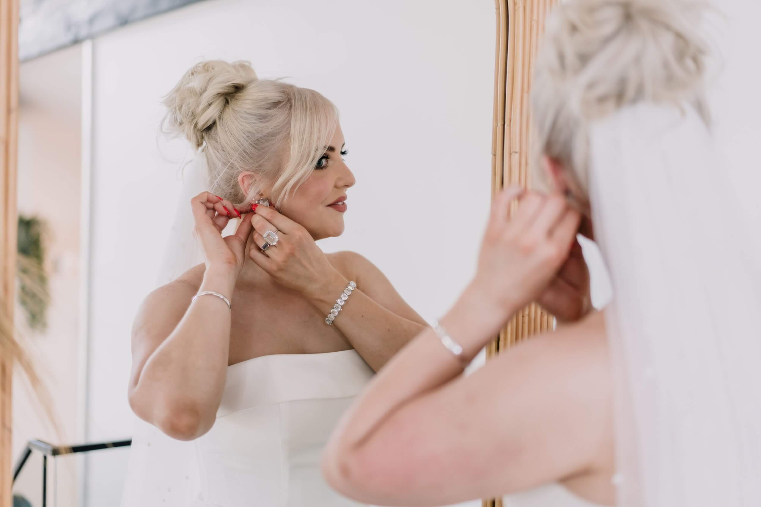 Bride getting ready in front of the mirror at Moonah Links accommodation
