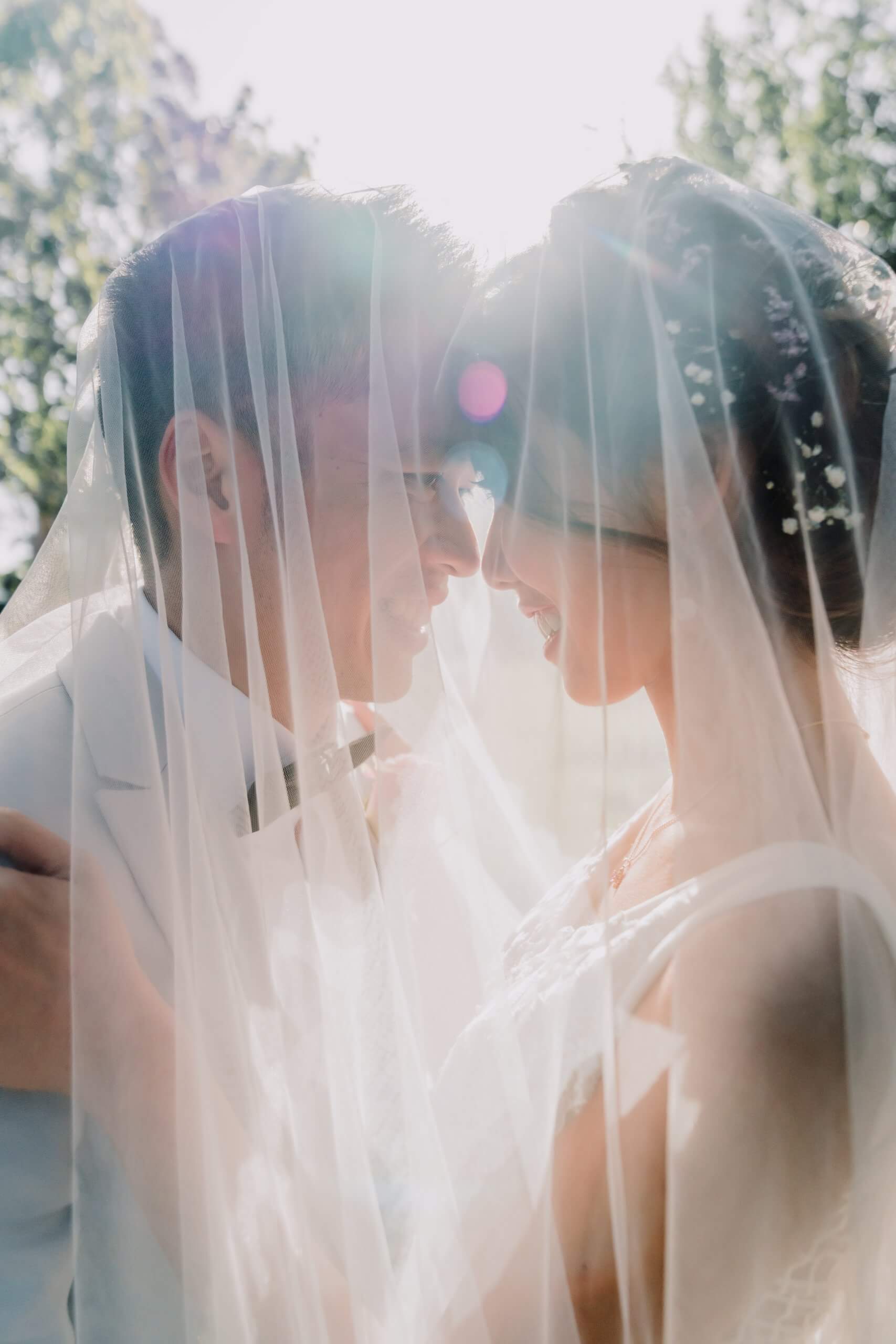 Narrative Portraiture - Bride and Groom under one veil and looking at each other