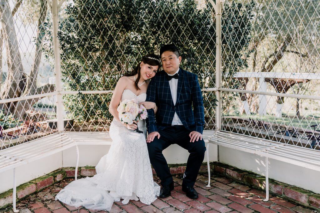 bride and groom sitting with the bride's head on the groom's shoulder