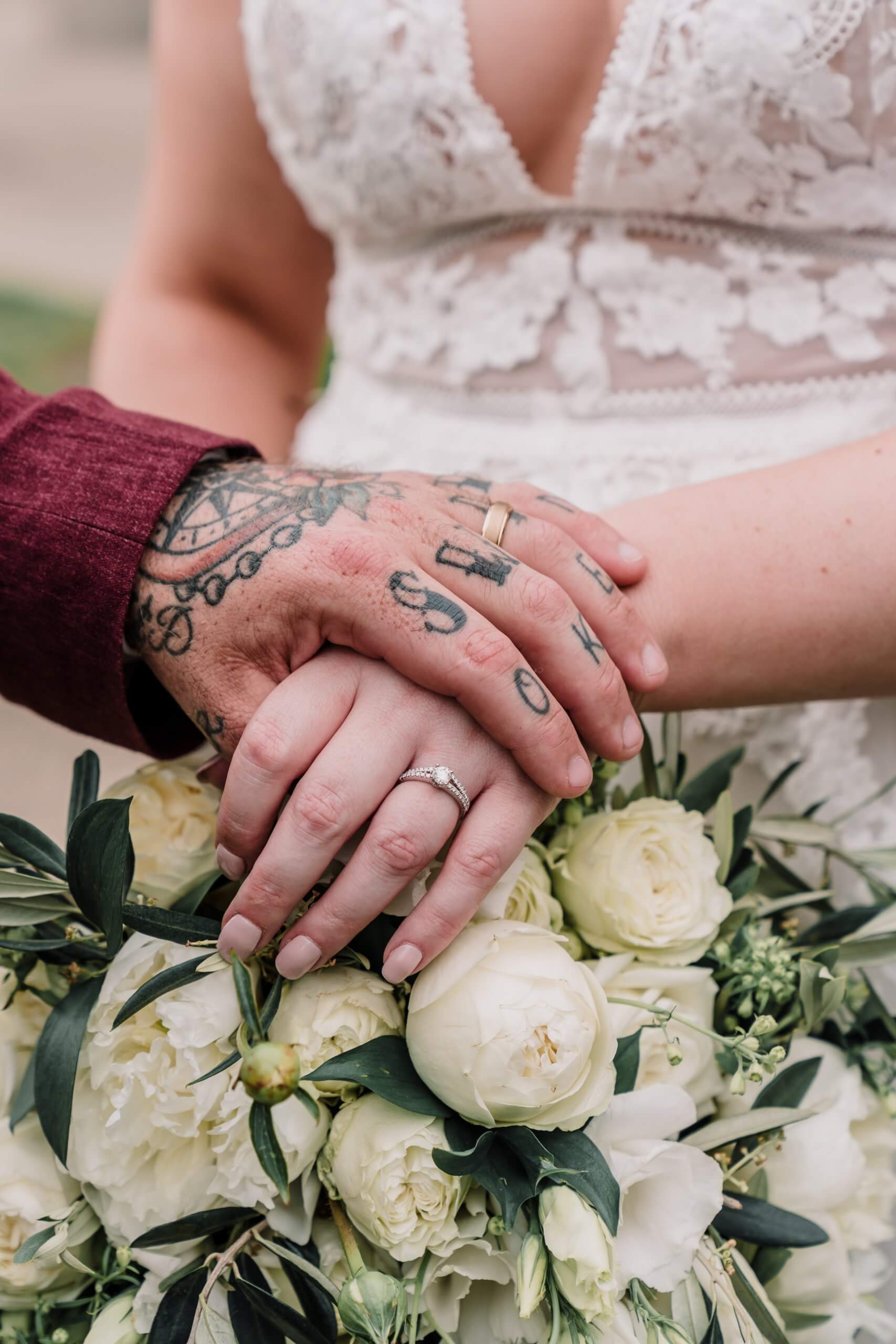 Narrative Portraiture - The groom holding the bride's hand and showing their rings
