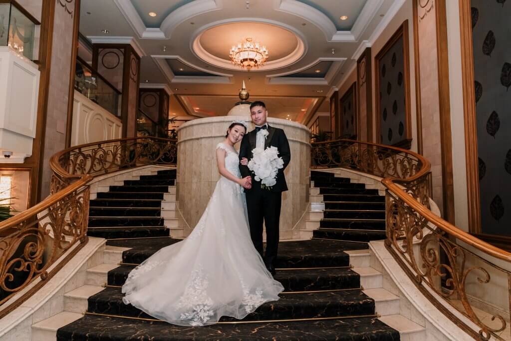 The bride and groom smiling from the top of the stairs at Metropolis Events