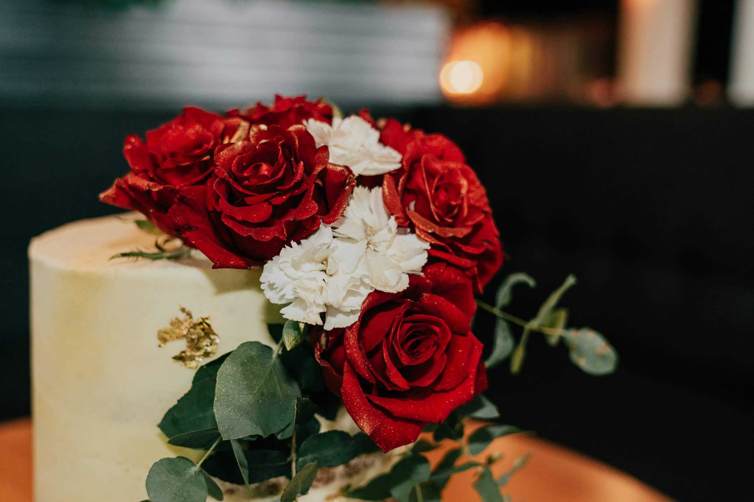 Detail shot of intricate red roses decorating a wedding cake