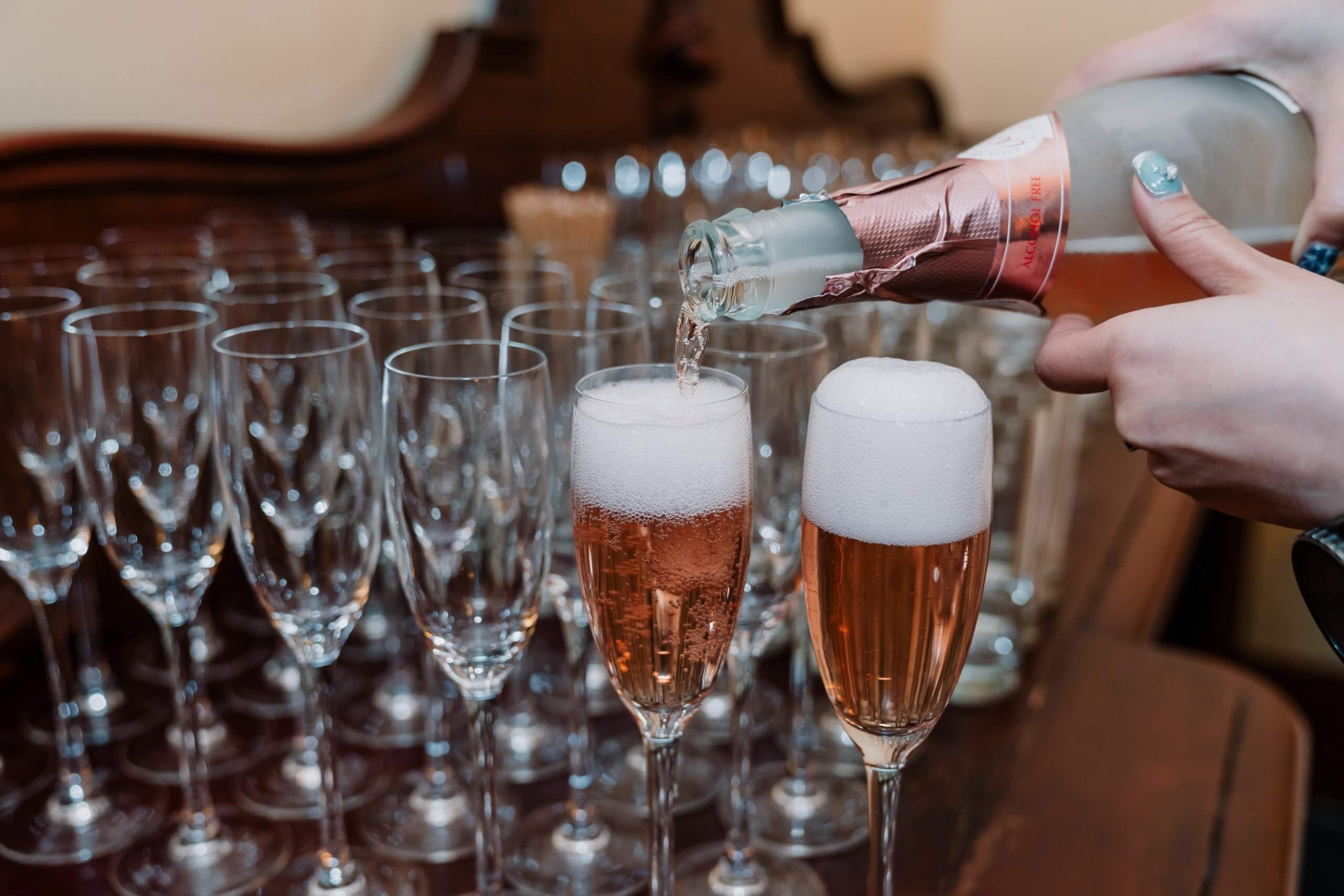 Detail shots of glasses, with two filled with bubbly champagne