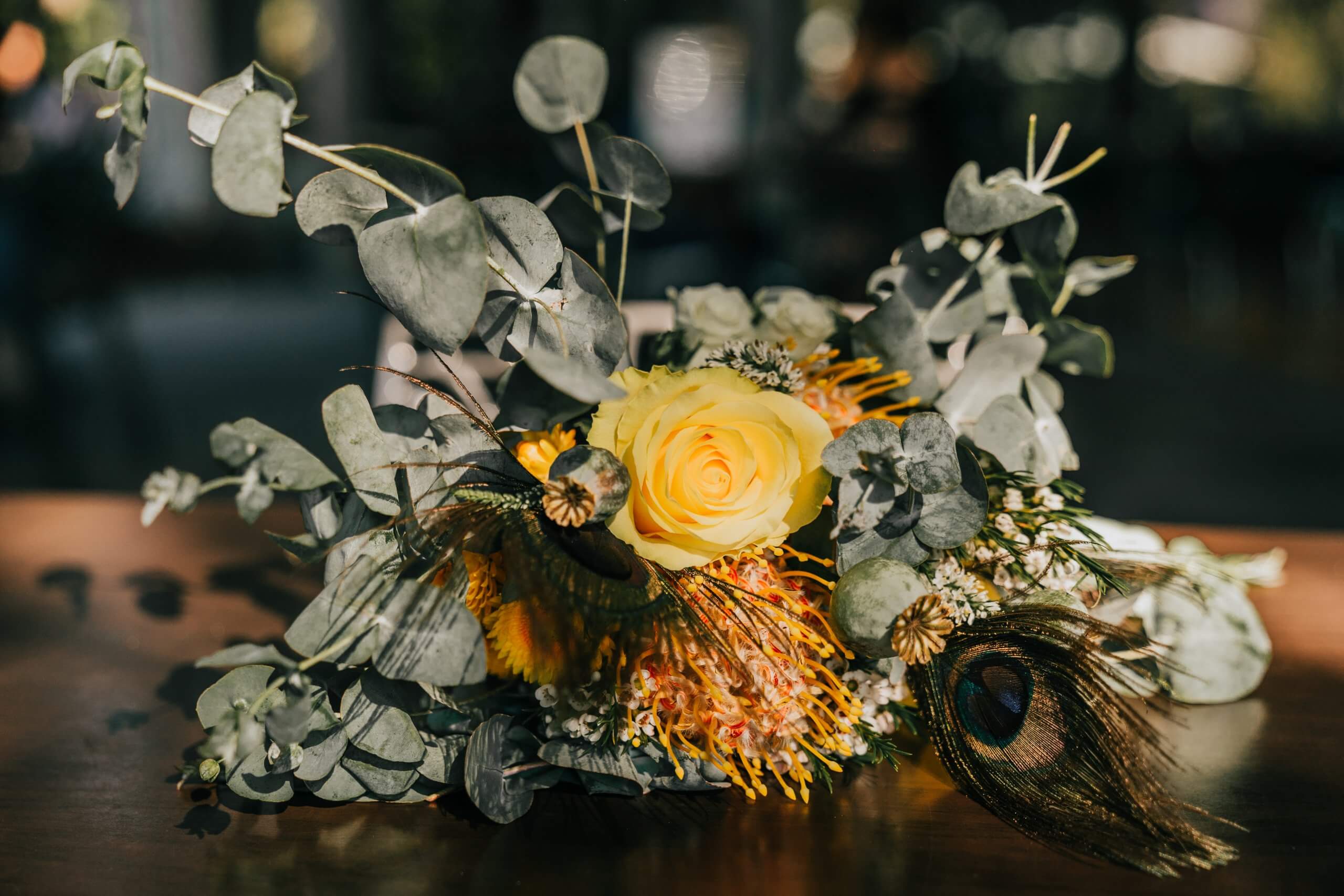 Detail shot of a yellow bouquet with peacock feathers