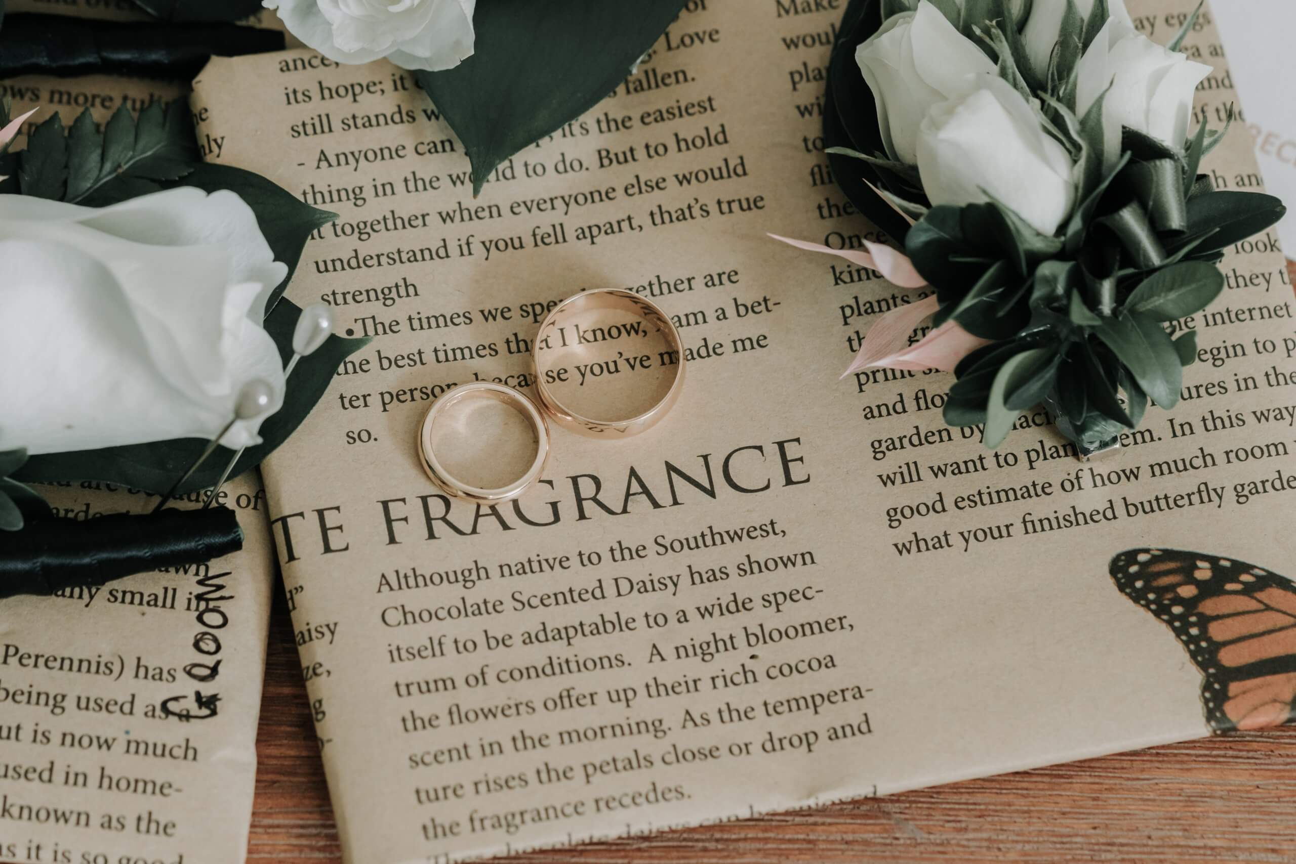 Detail shots of marriage bands on top of a newspaper